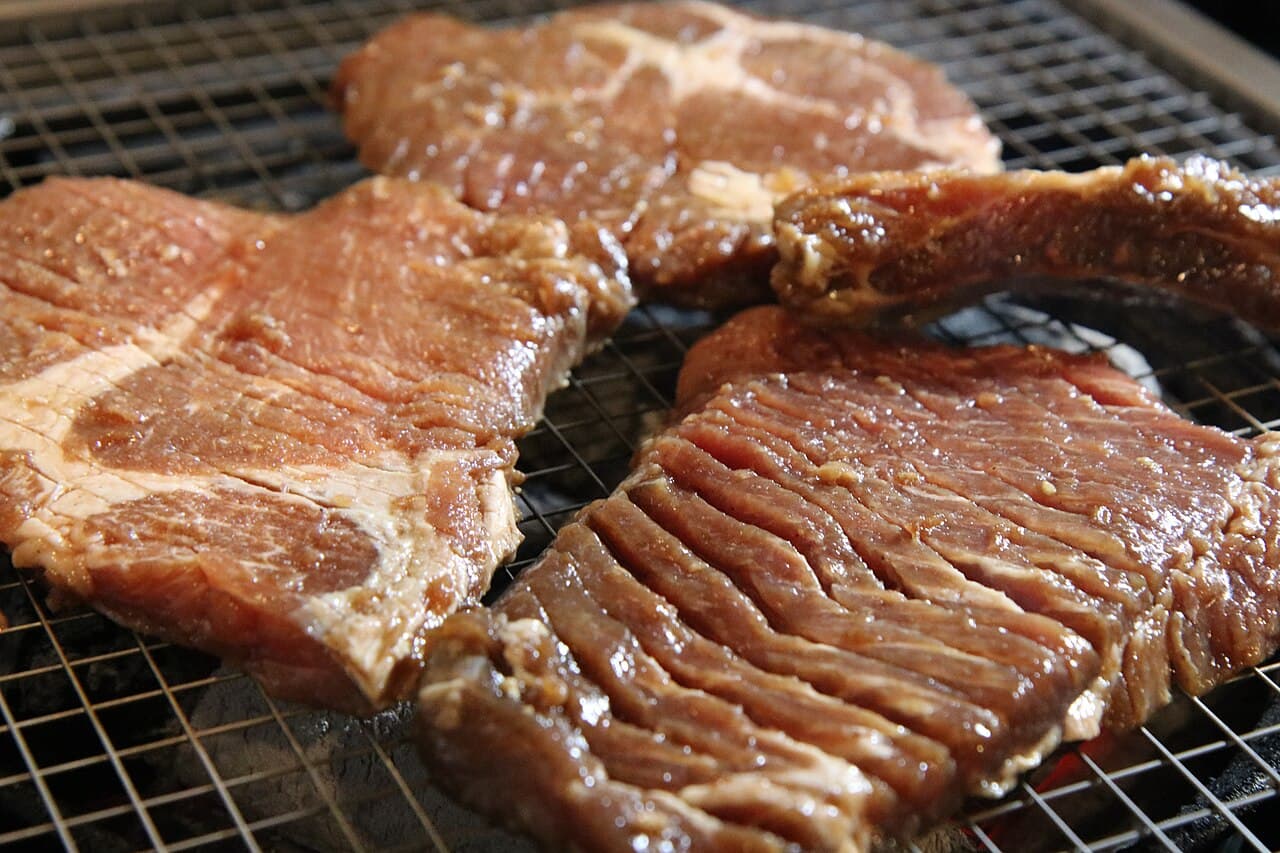 Marinated galbi short rib slices on a wire rack, glossy with marinade