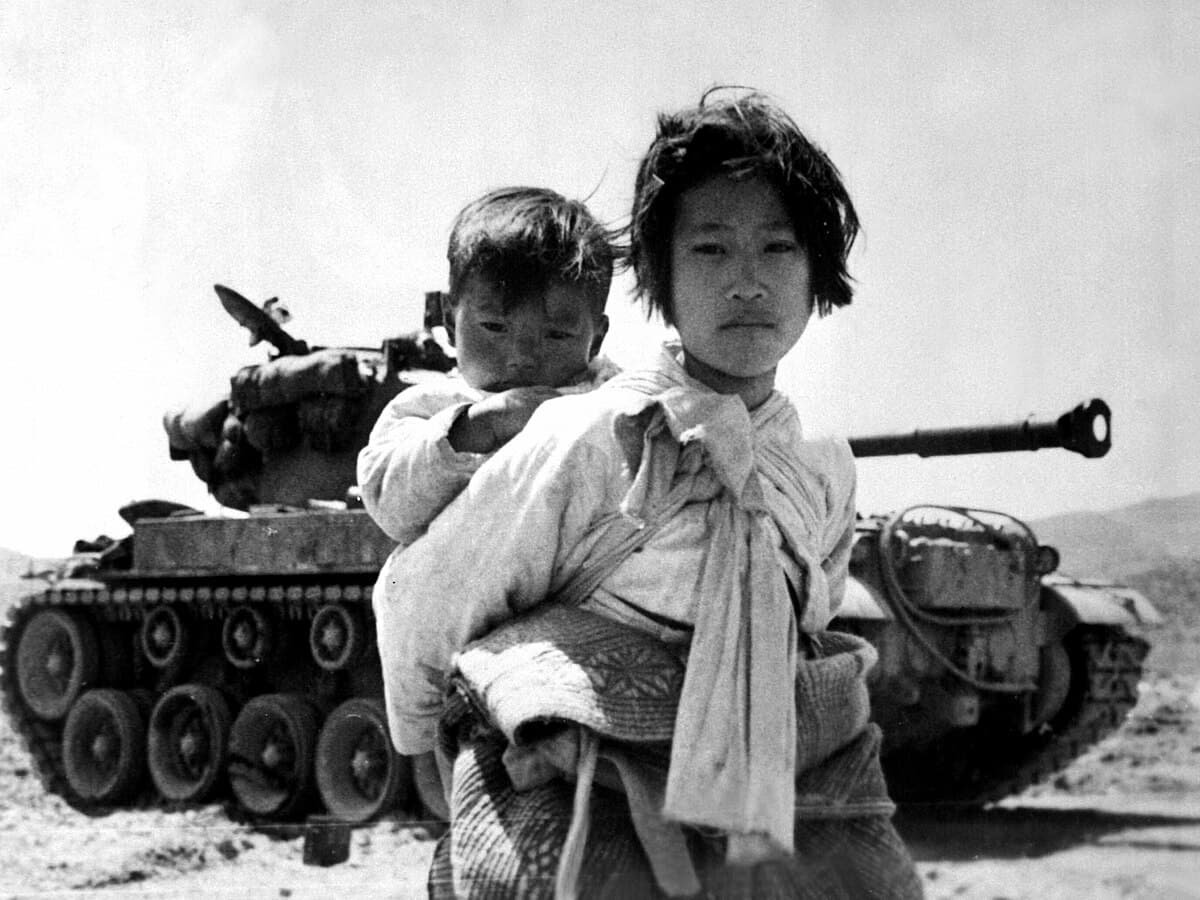 1951년 6월 한국전쟁 당시 행주 인근에서 멈춰 선 M46 패튼 탱크 옆을 동생을 업고 지나가는 어린 여자아이