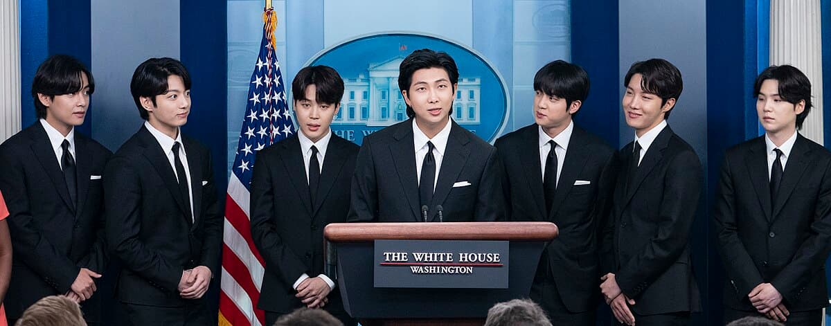 2022年5月にホワイトハウスで記者会見に臨む、黒のフォーマルスーツを着た7人のBTSメンバー